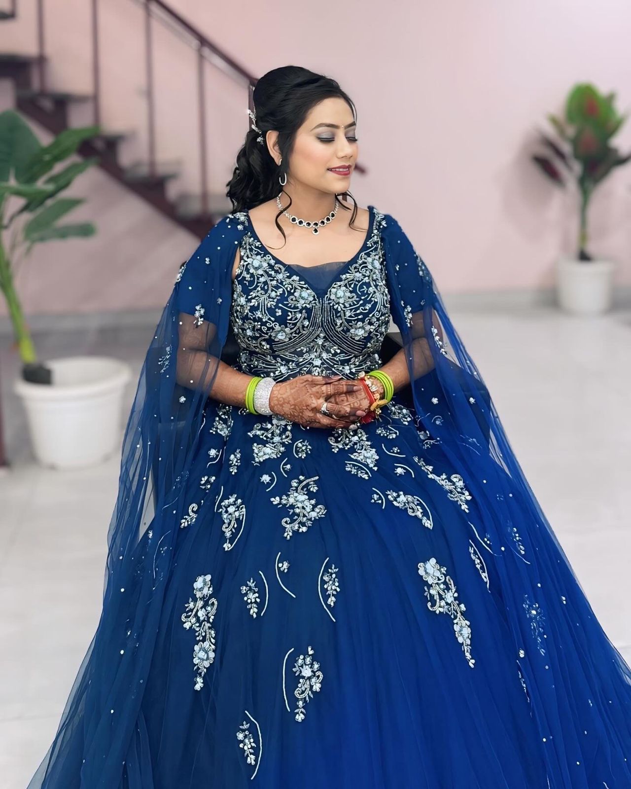 Bride in navy blue gown with floral embroidery
